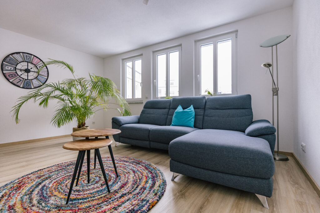 Arbeitsplatz am Fenster mit rotem Sofa in gemütlichem Dachzimmer
