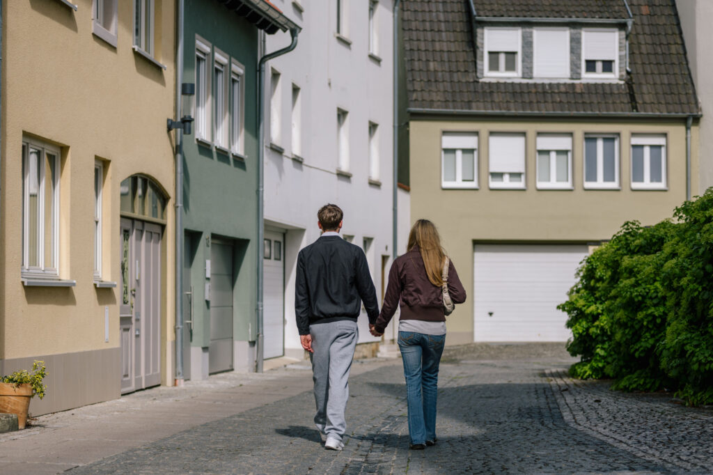 Paar geht Hand in Hand durch die Pflastersteingasse vor dem Ferienhaus Alte Pfarrgasse